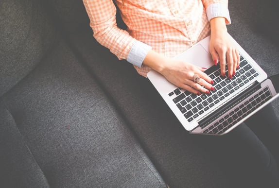 Woman sat on a sofa with laptop open to represent content mapping
