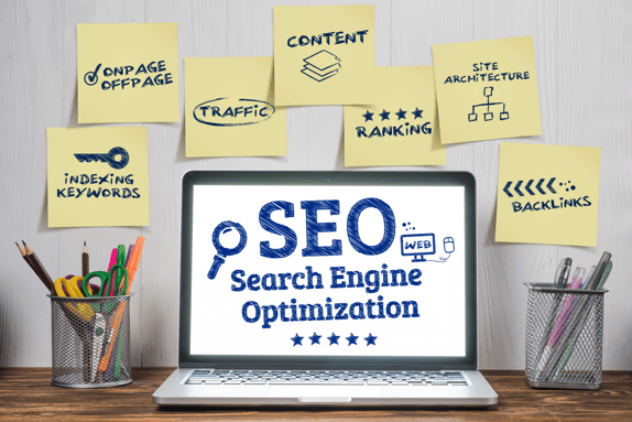 Laptop displaying "SEO" and surrounded by post-it notes to represent inbound marketing strategy