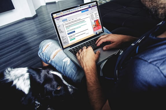 Person in casual dress with laptop open on lap to represent lead nurturing emails