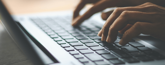 hands typing on a keyboard representing seo strategy using E-A-T