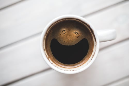 Mug of coffee with bubbles in the shape of a smiley face to represent website usability testing