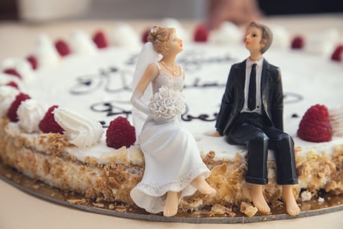 Bride and groom ornaments on top of a wedding cake to represent CTAs for B2B content marketing
